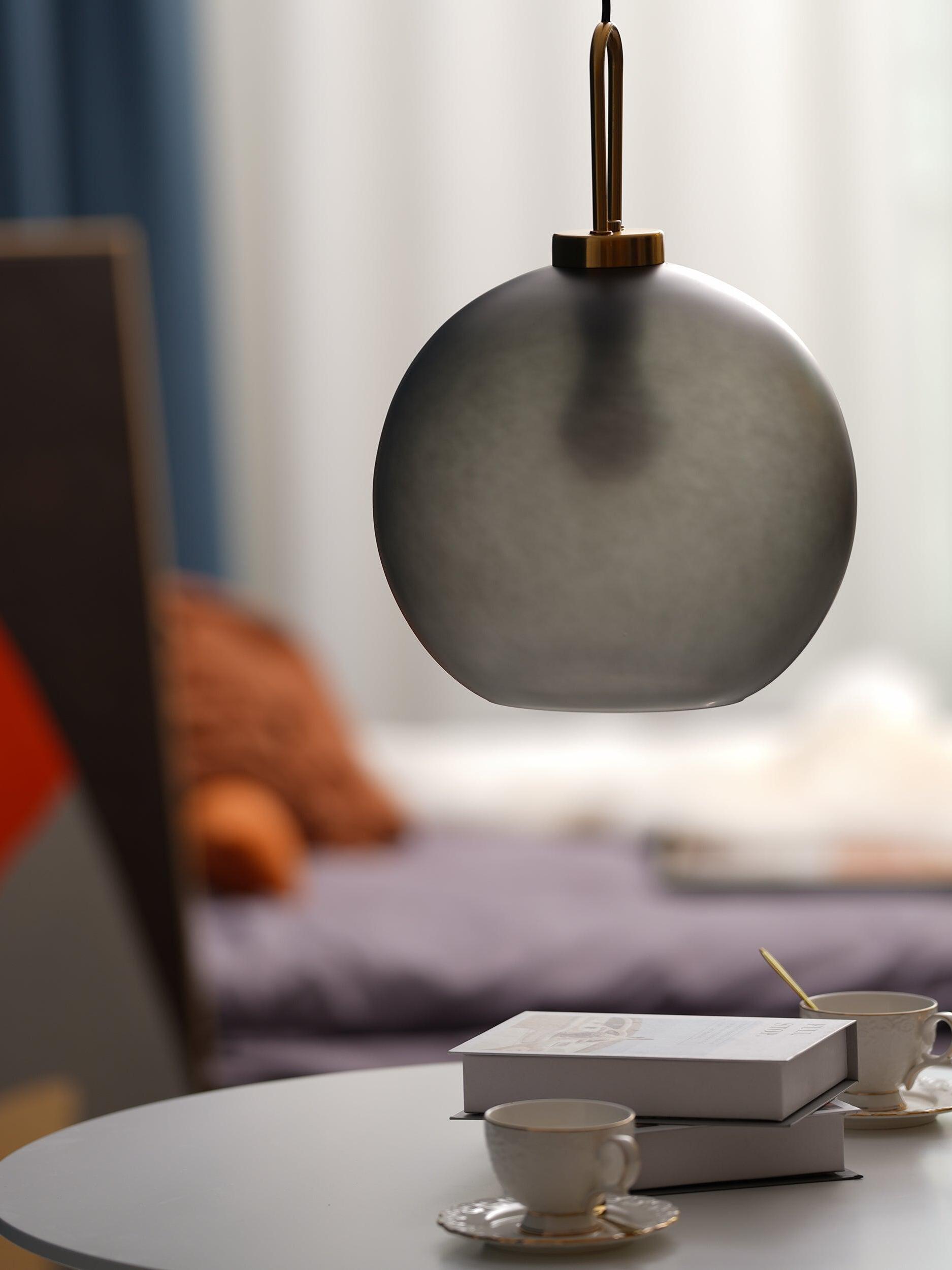 Grey glass sphere suspended over a round table
