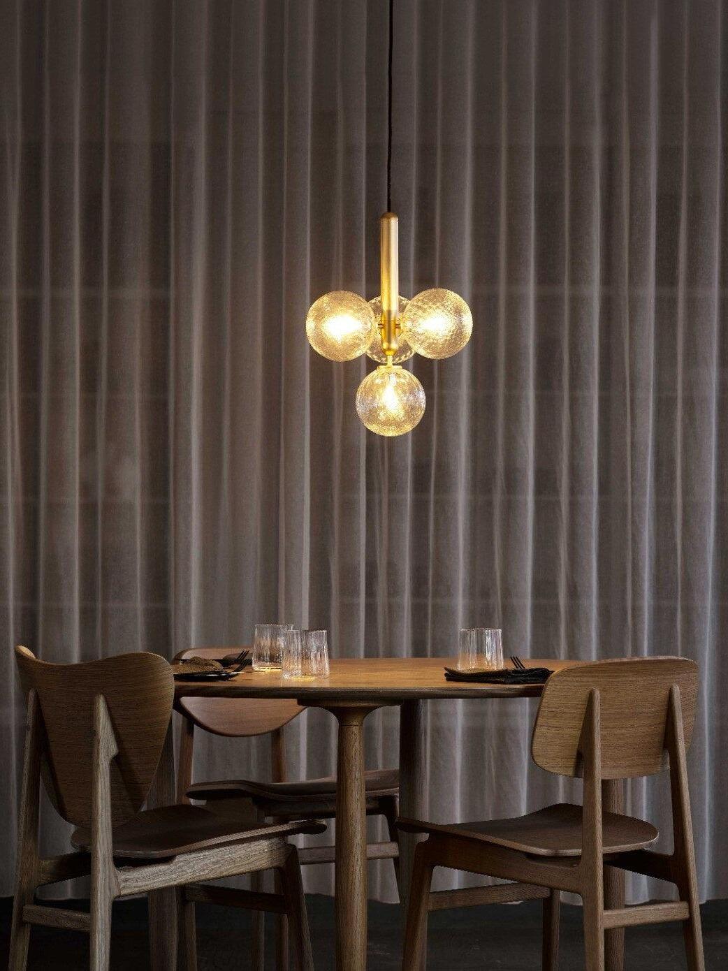 Gold-coloured clustered globe pendant above a dining table