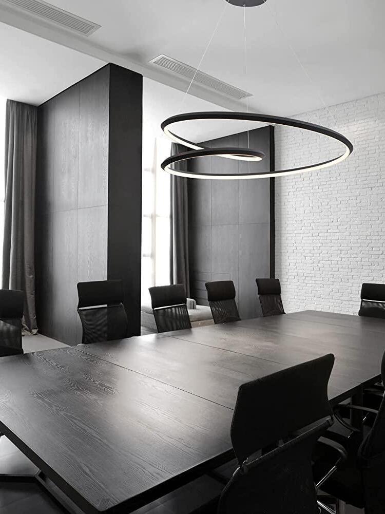 Black looping chandelier over a dark dining table