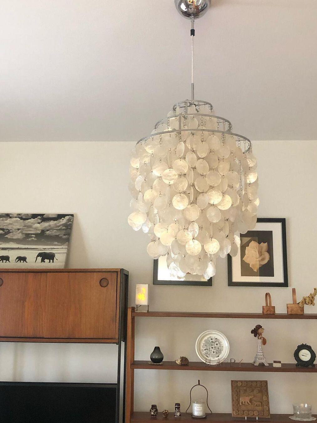 Tall white shell pendant above a dining area