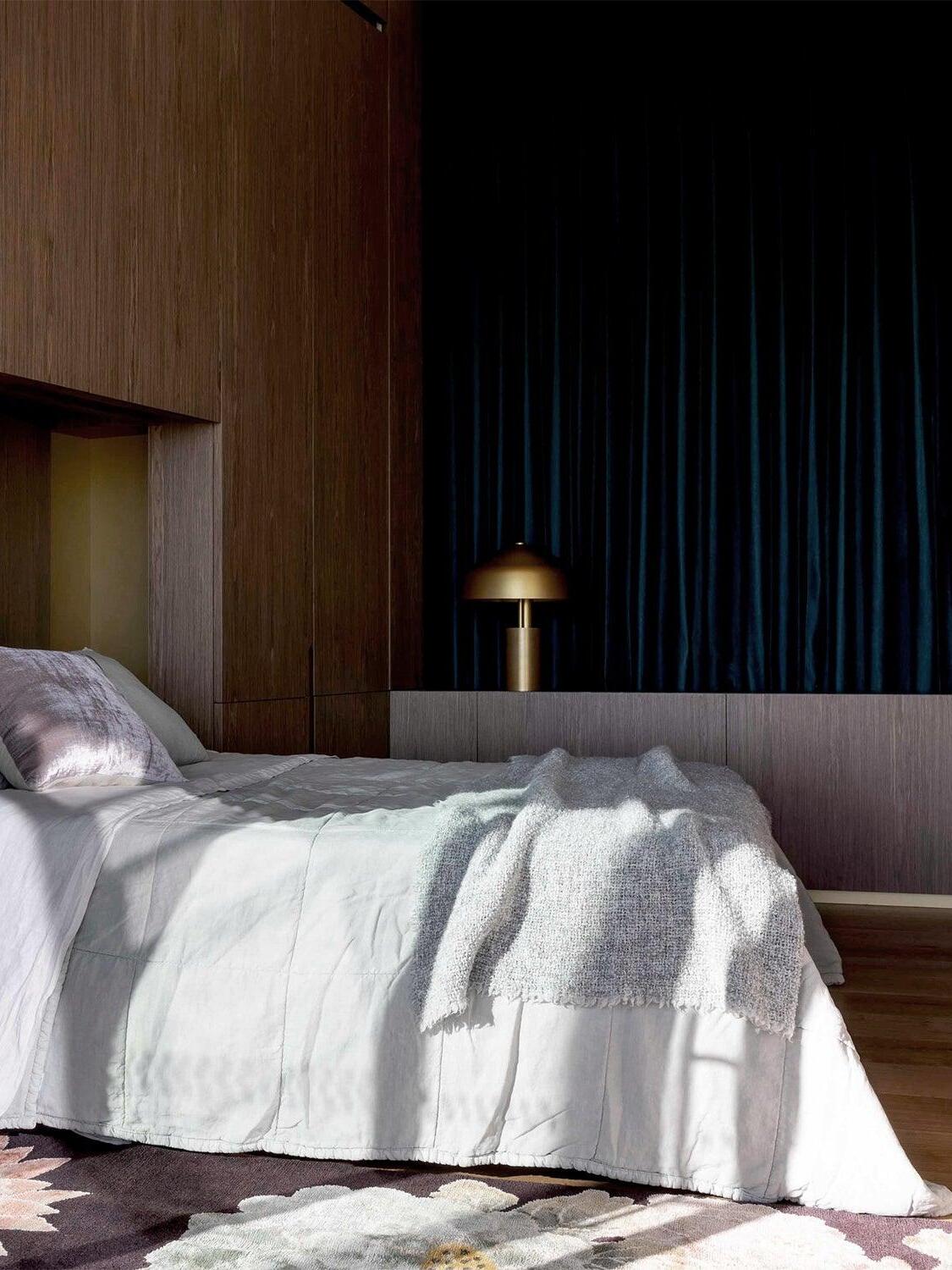 Gold dome lamp beside bed in dark bedroom