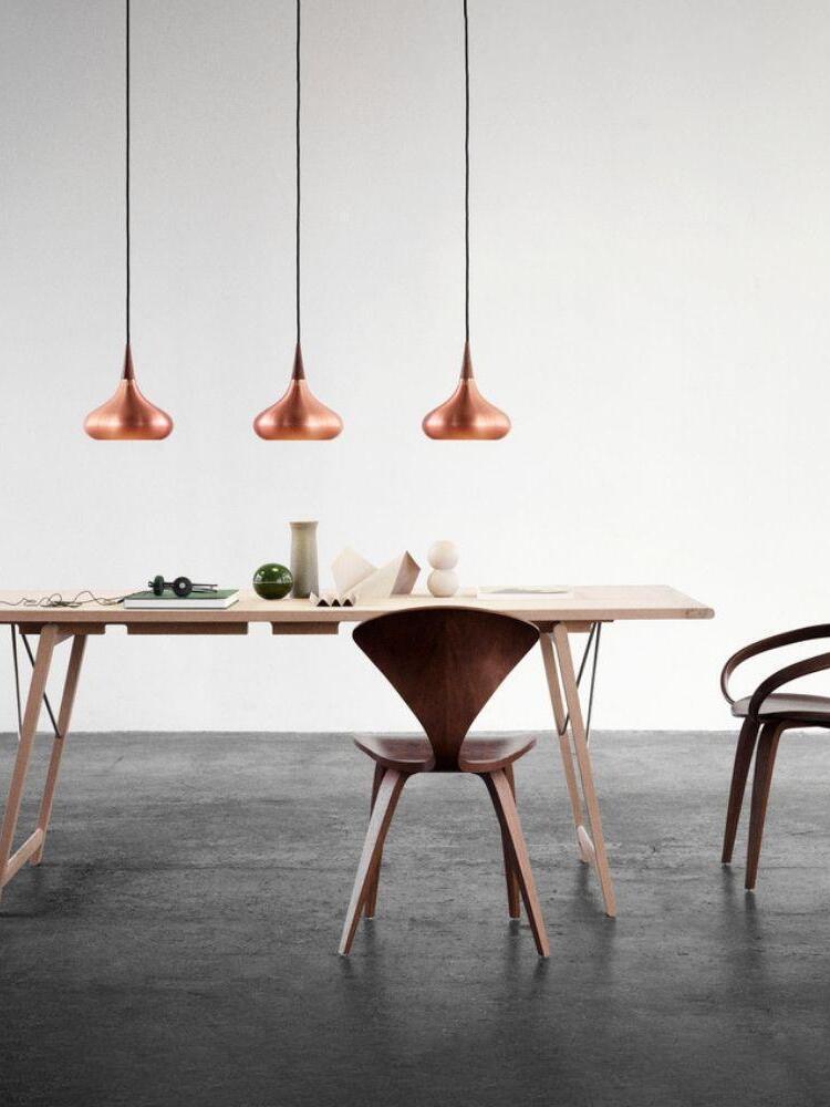 Three Copper pendants arranged over a dining table