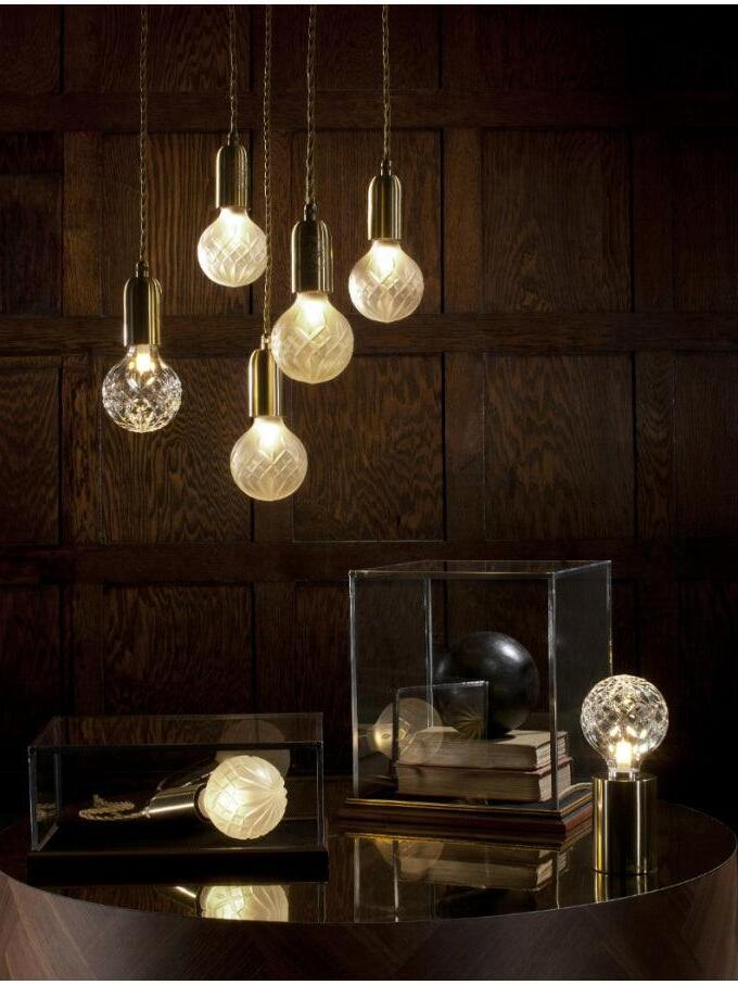 Hanging glass globes and separate table lamps in dark room