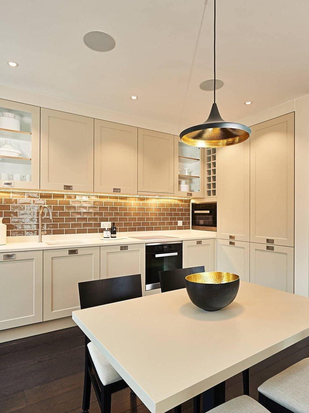 Wide shallow pendant above a pale table