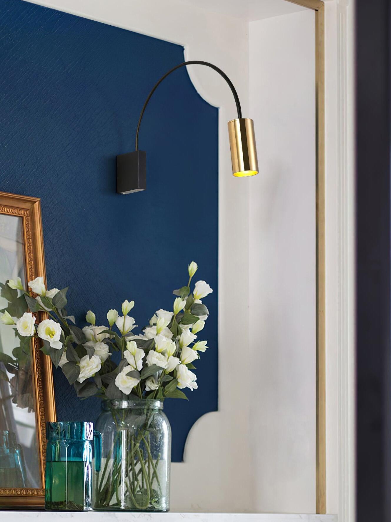 Antonella wall lamp above flowers against a blue wall