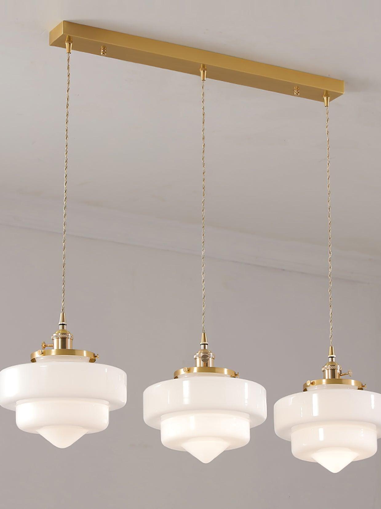 Atlas Model A three-head option with flat stepped white glass shades and pointed tips beneath a shared brass canopy