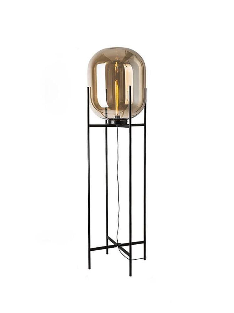 Amber Oda glass shade on a tall open black metal stand against white.