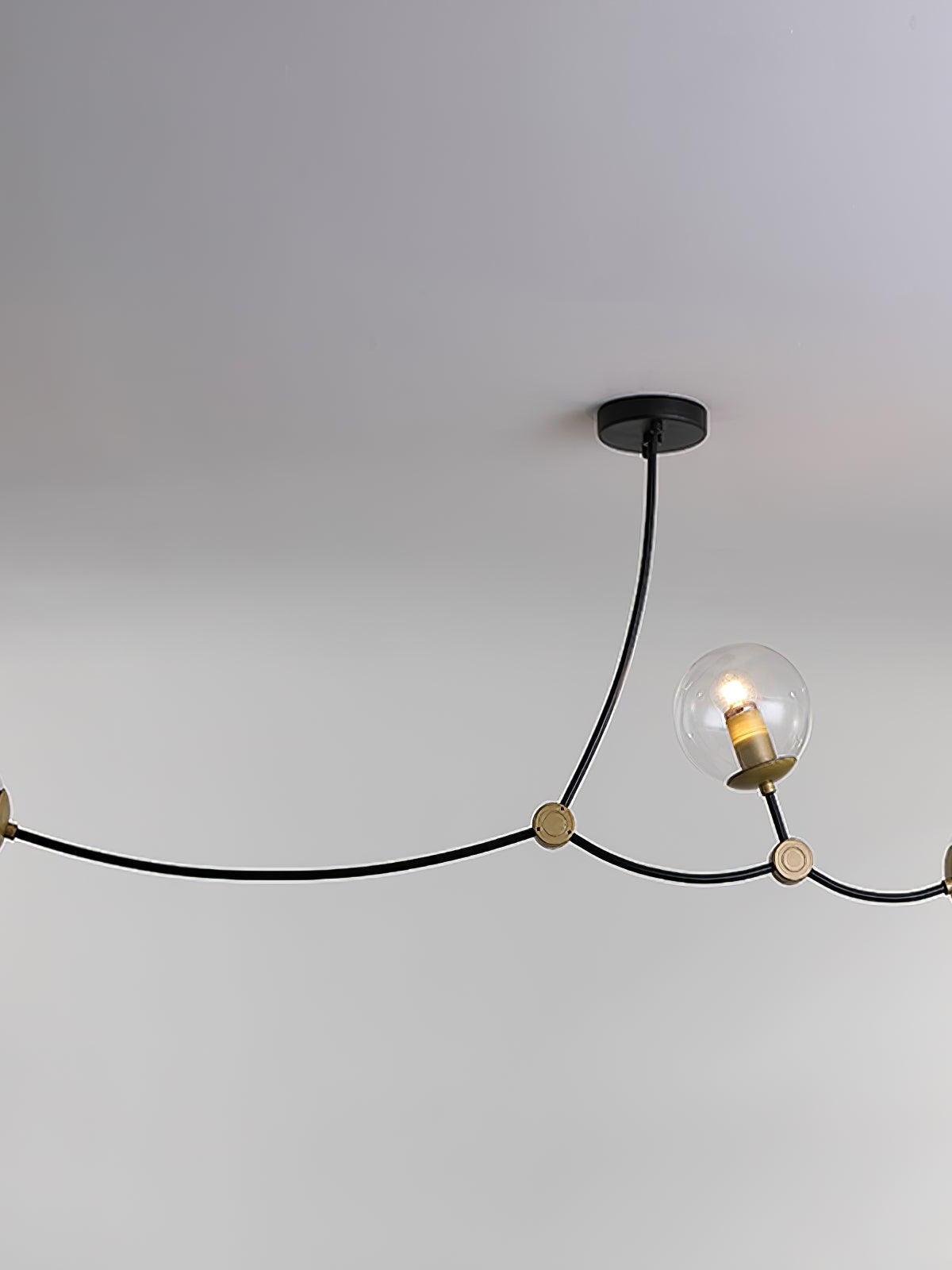 Close view of a clear glass globe on a long curved black chandelier arm