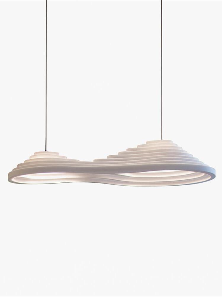 Isolated elongated white pendant with two raised sections and two suspension cables.