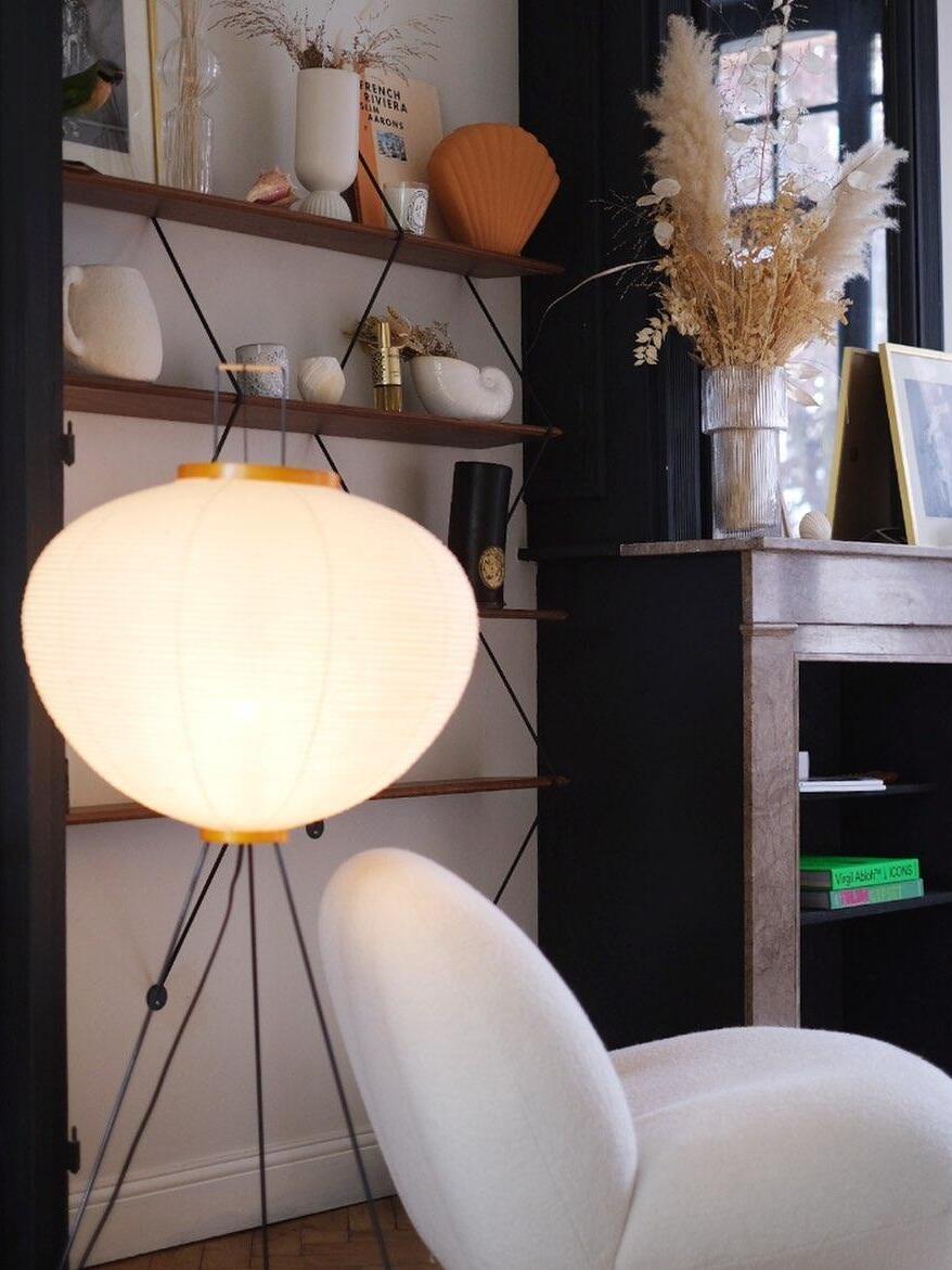 Illuminated paper shade near a bookshelf