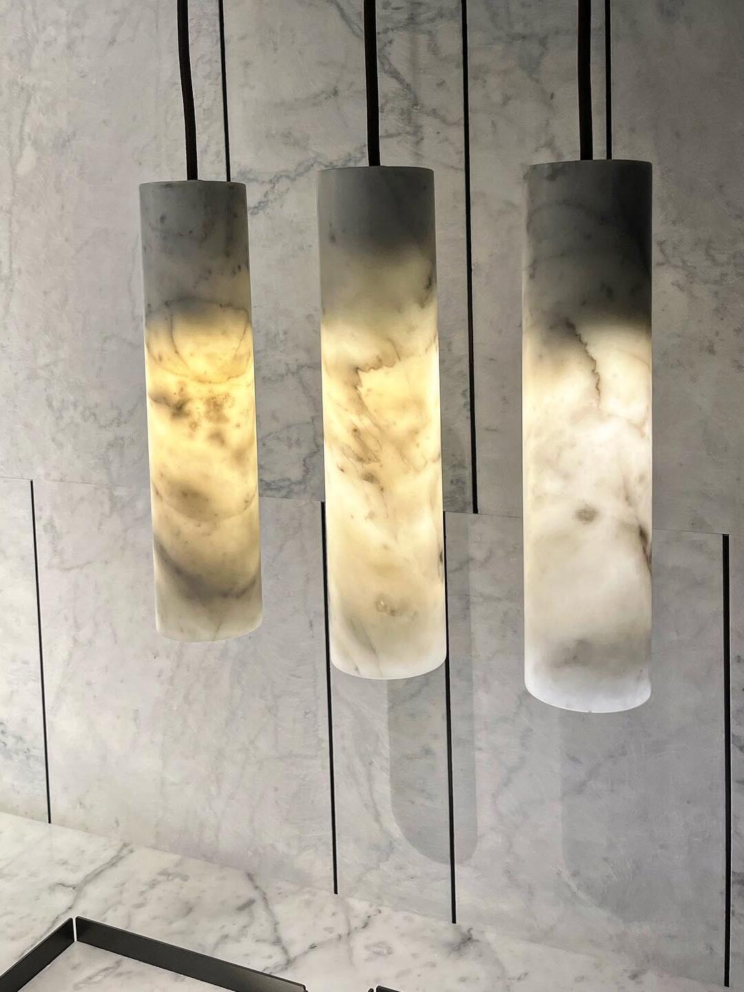 Three glowing Silo cylinders with visible stone patterns against a pale panelled wall