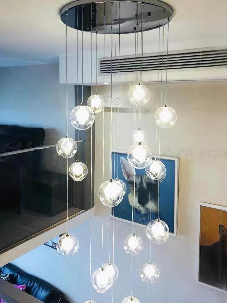 Round chrome canopy and globe cluster over open room