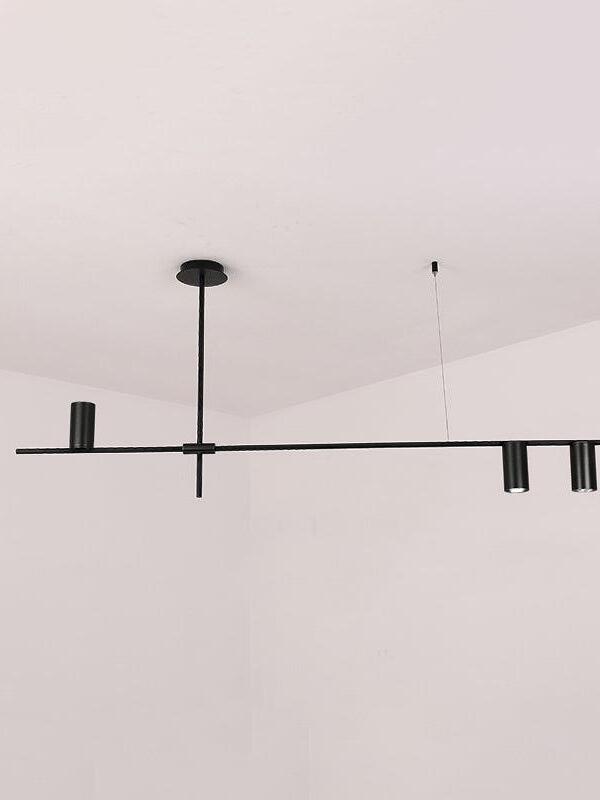 Black linear chandelier with three cylindrical light heads and a slender central suspension stem