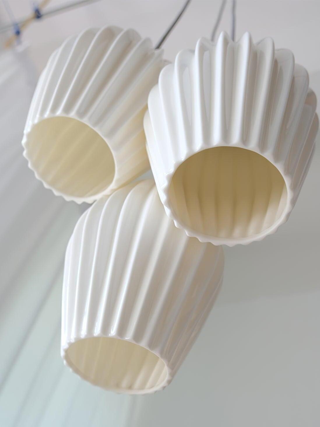 Underside view of three white ceramic shades showing ribbed surfaces and open bottoms