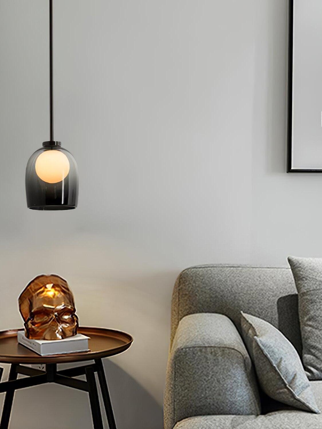 Gradient-black Crux pendant beside a grey sofa and round side table