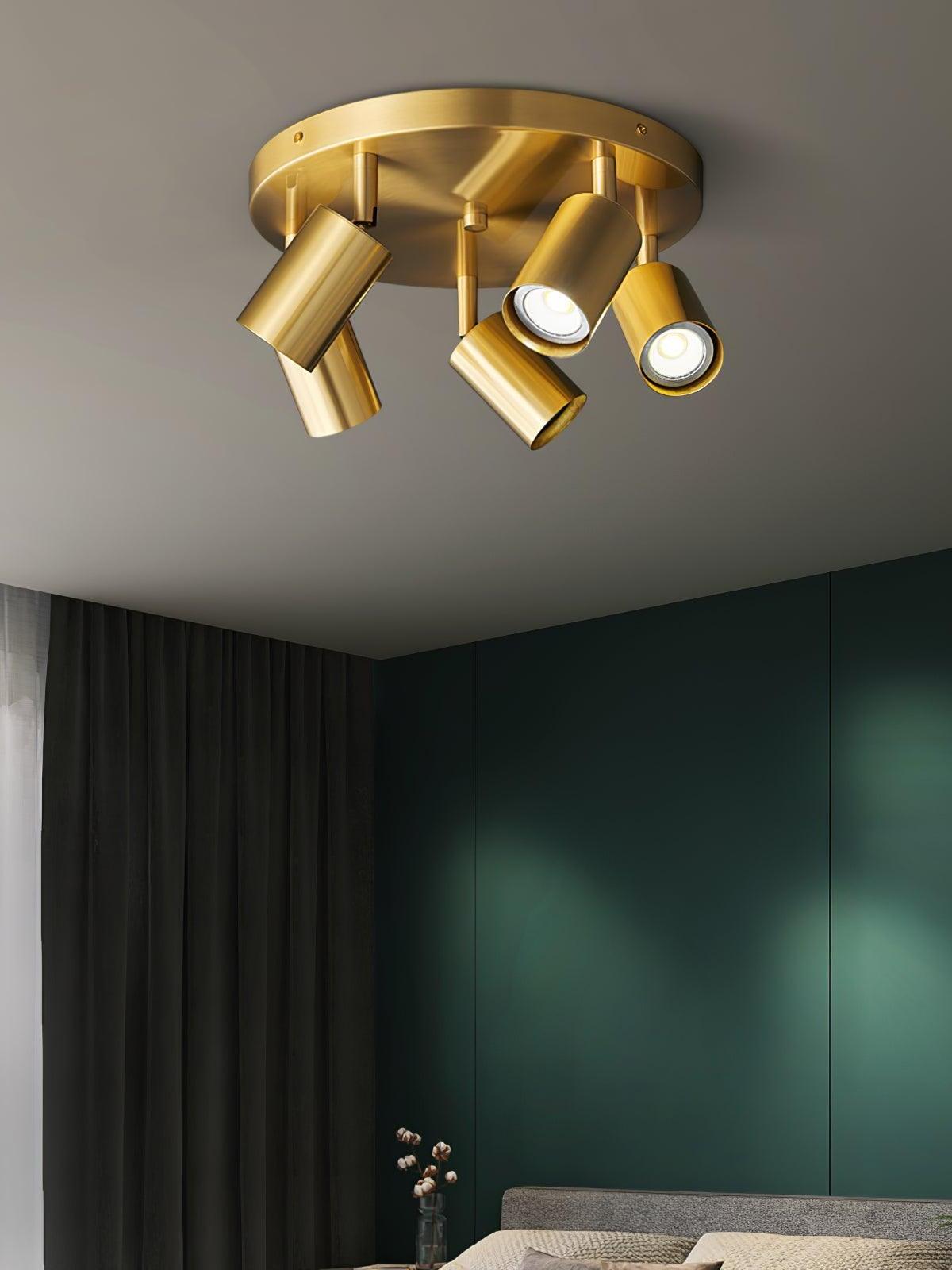 Brass five-head Hugo spotlight in room with green wall