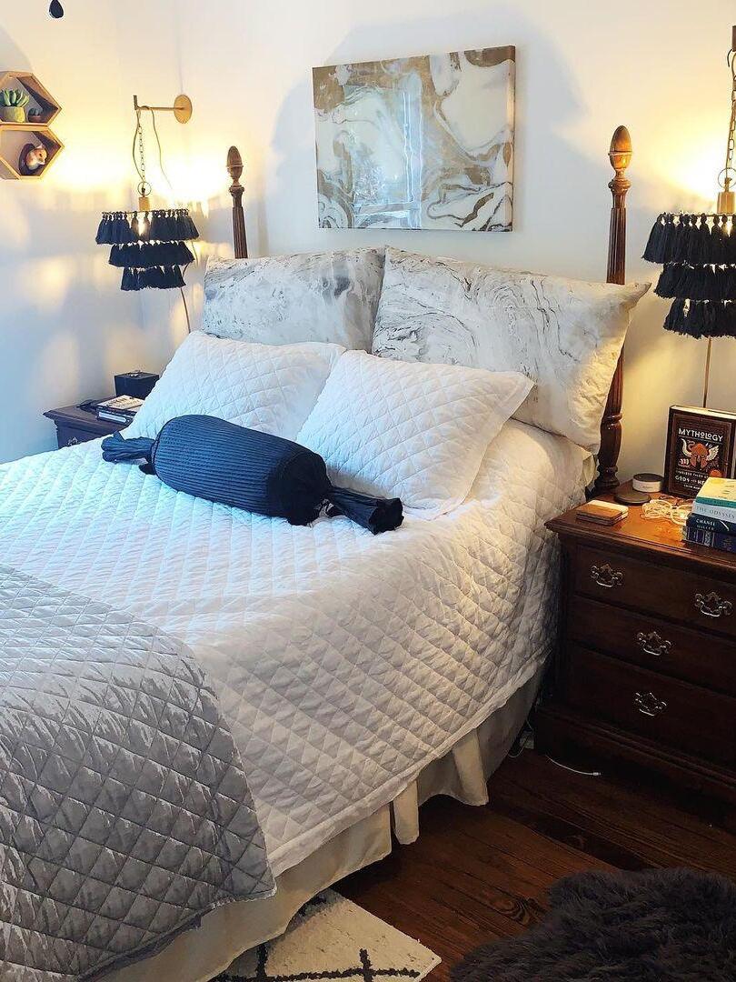 Two blue tassel lights pictured beside a bed