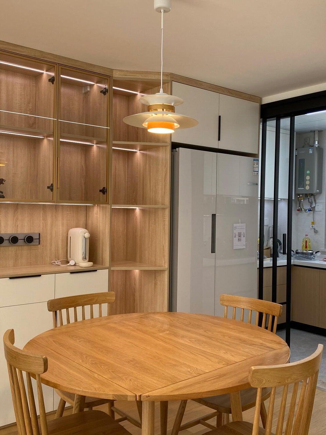 Layered pendant over a round wooden dining table