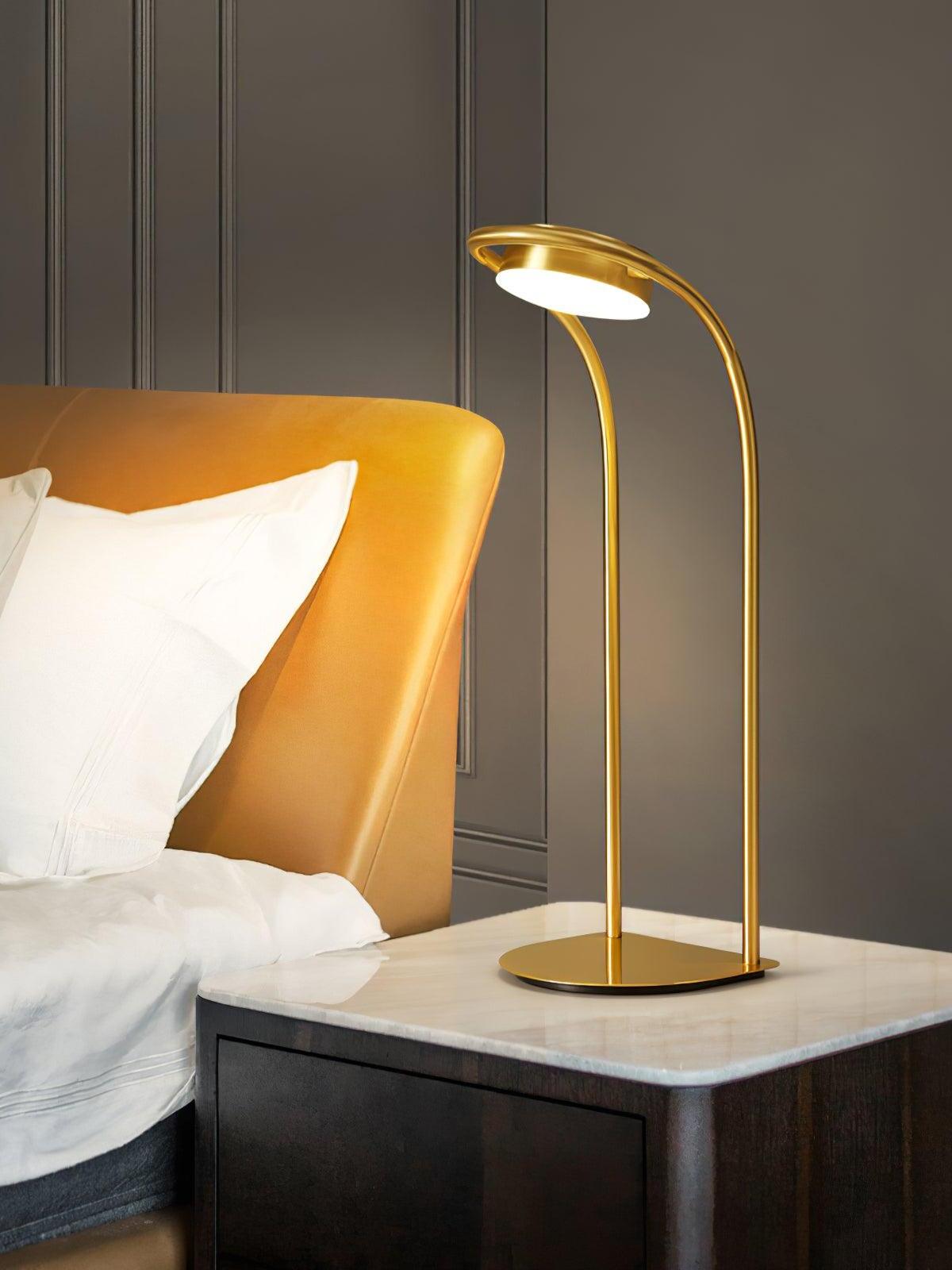 Curved brass lamp beside bed with orange headboard