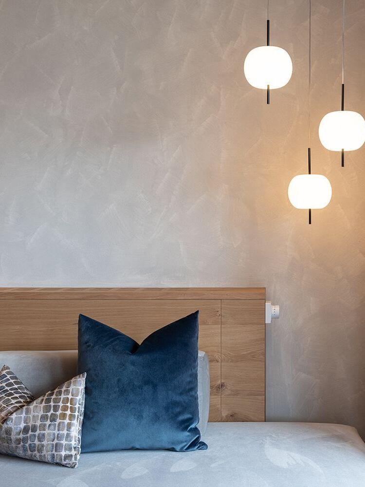 White pendants with black stems above a bed