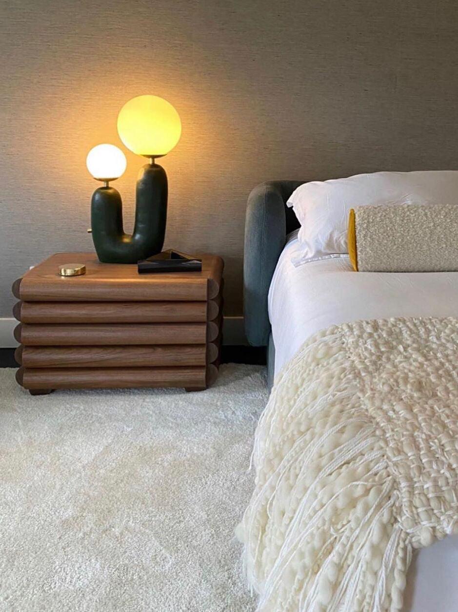 Green double-globe lamp on a bedside table