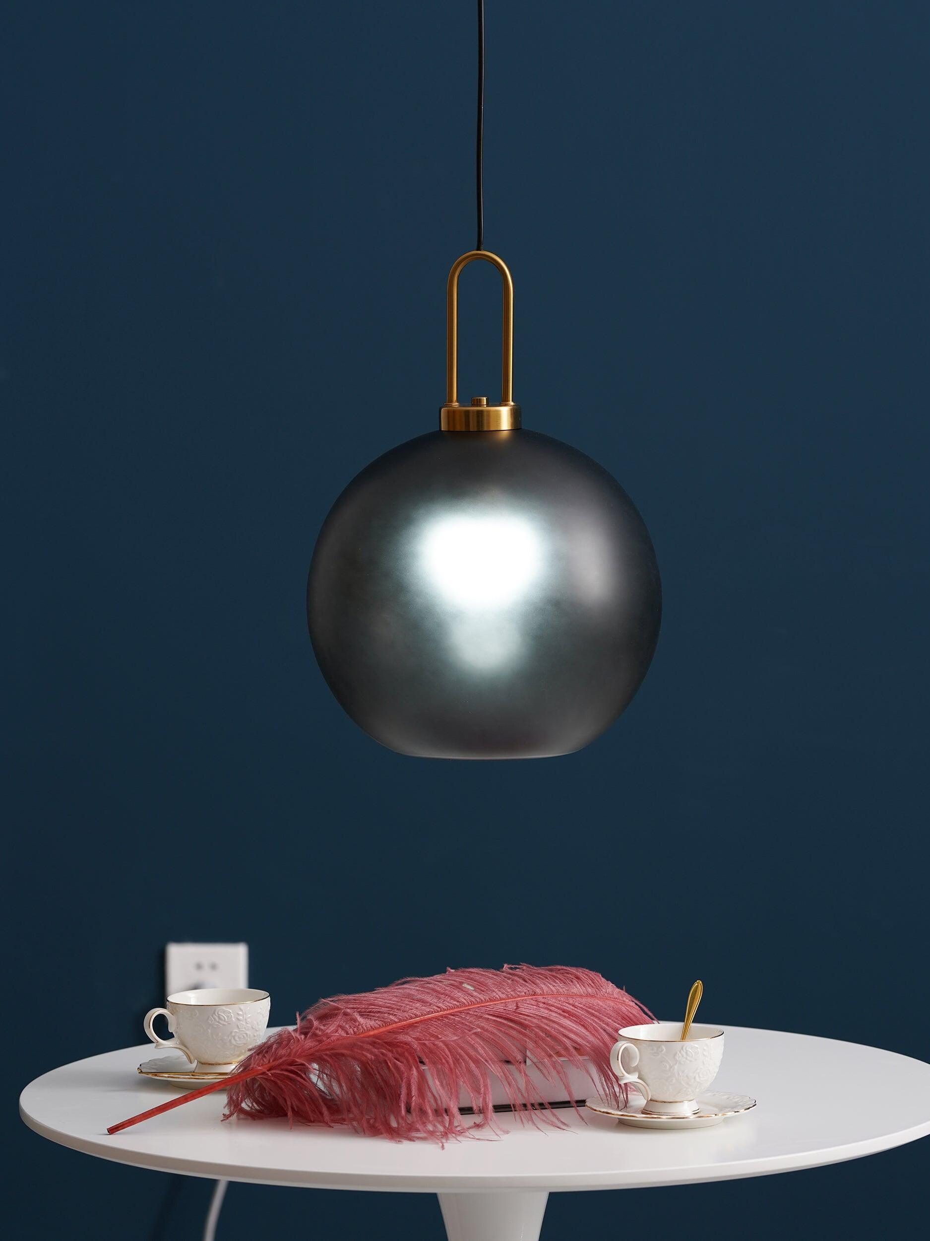 Small smoky glass globe above a table with a pink throw