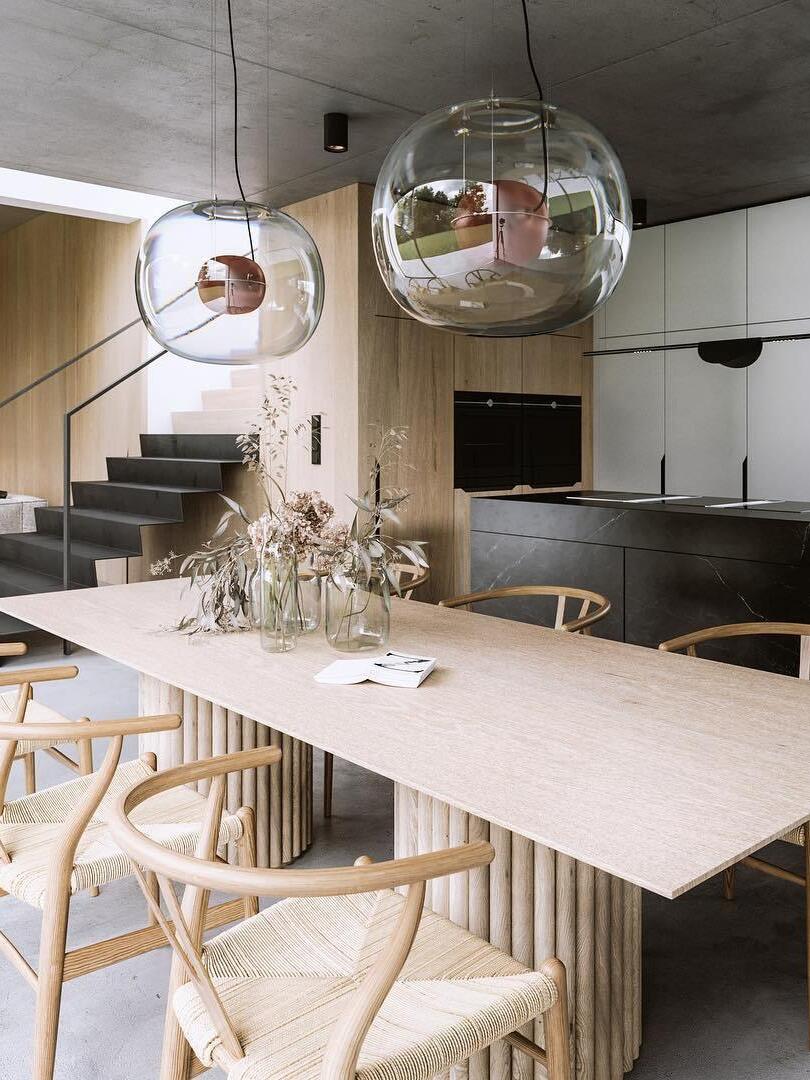 Glass globe pendants above a dining table beside stairs