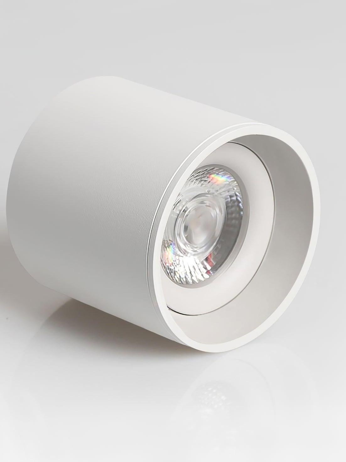 White Modupoint lying on its side, showing textured cylindrical body, inset circular optic and inner ring
