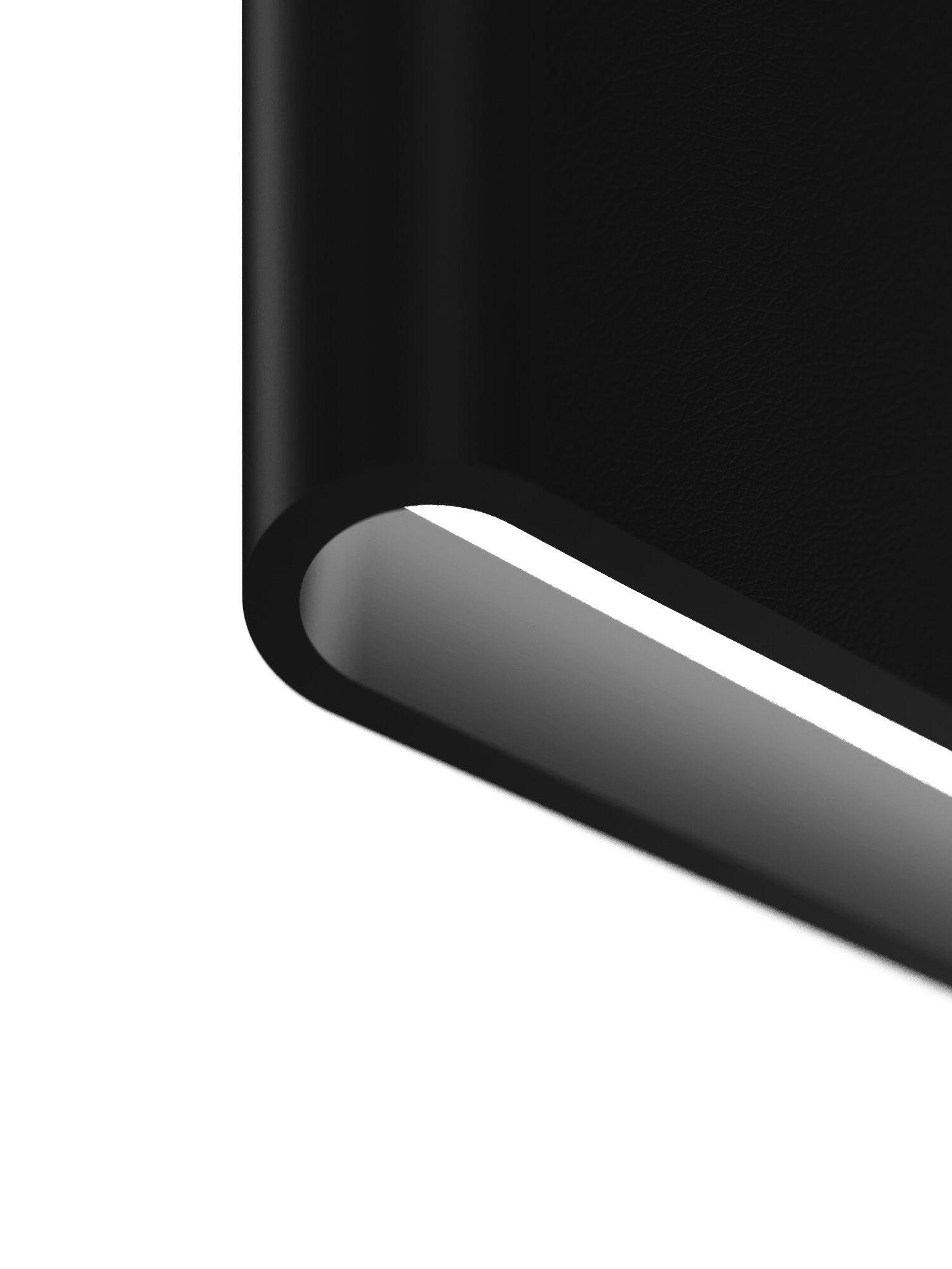 Macro of black textured material curving around a pale linear diffuser