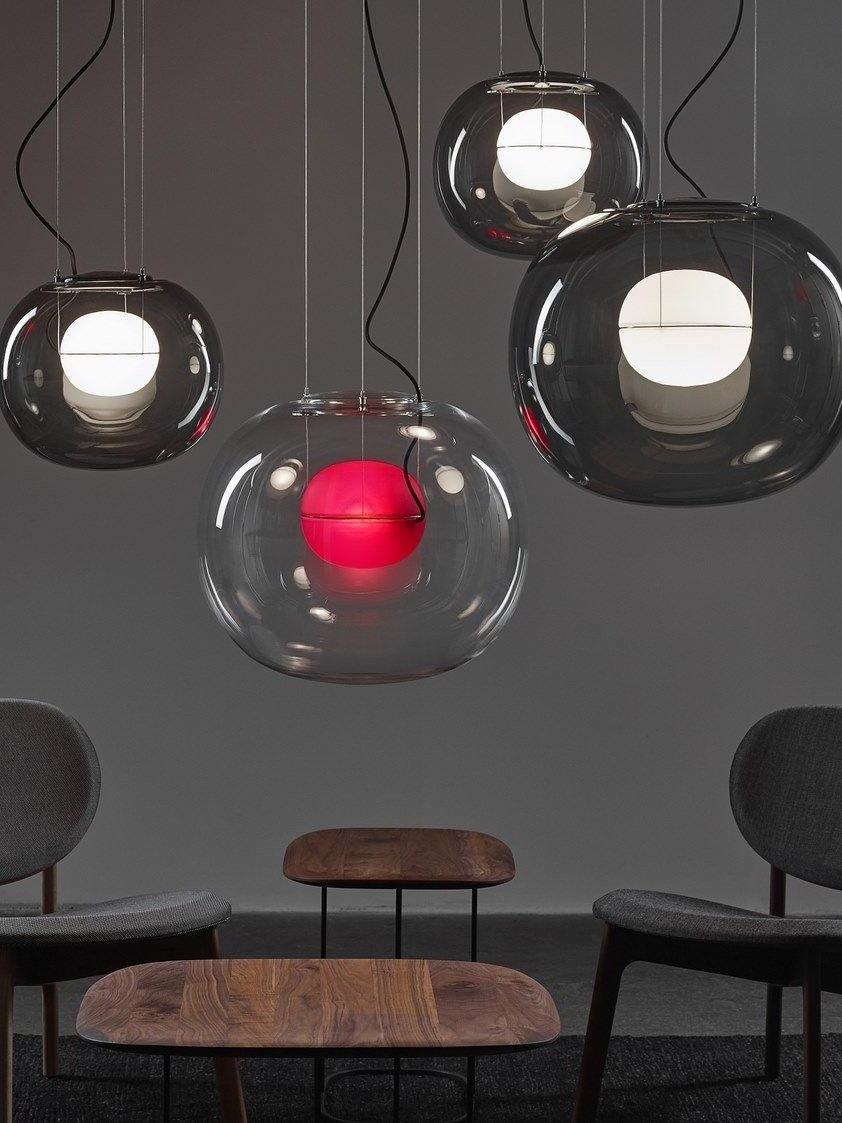 Clear and dark globe pendants above wooden chairs
