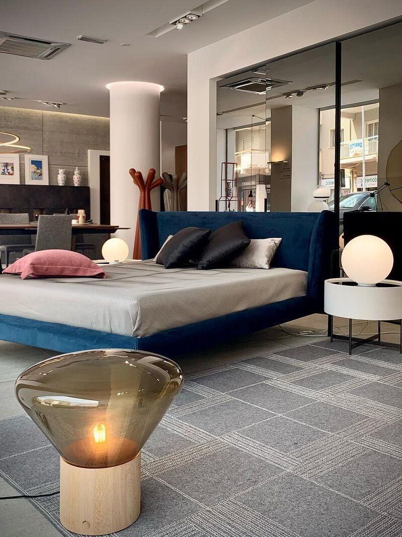 Amber glass lamp at floor level in bedroom with separate round bedside lights