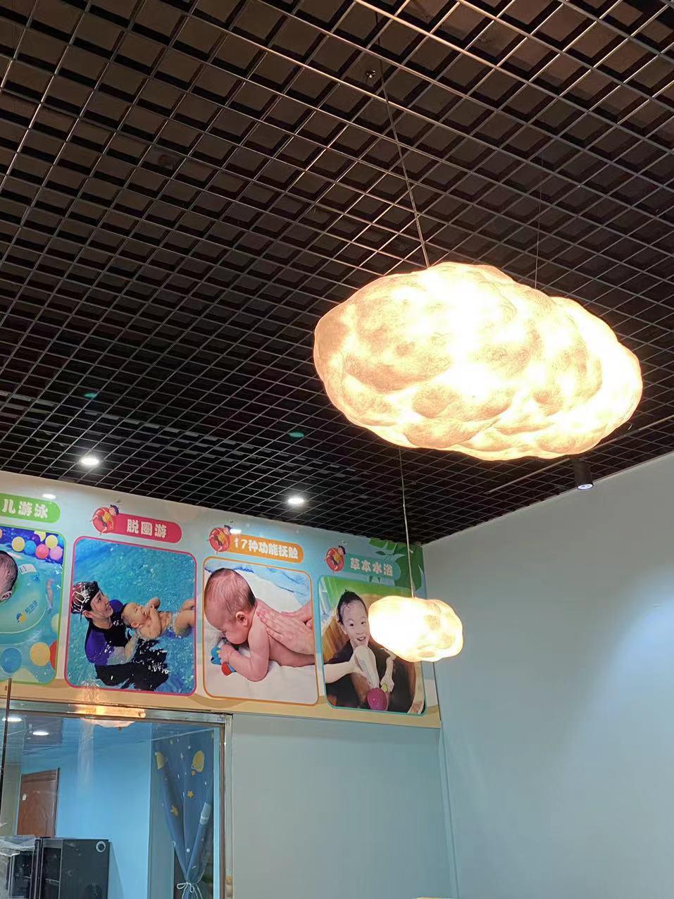Illuminated cloud shade beneath a grid ceiling