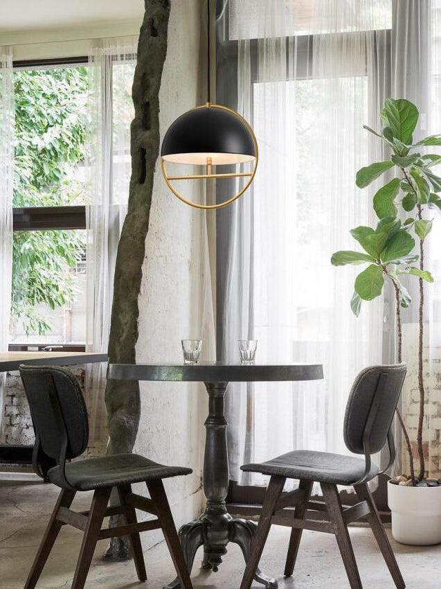 Black circular pendant above table by window