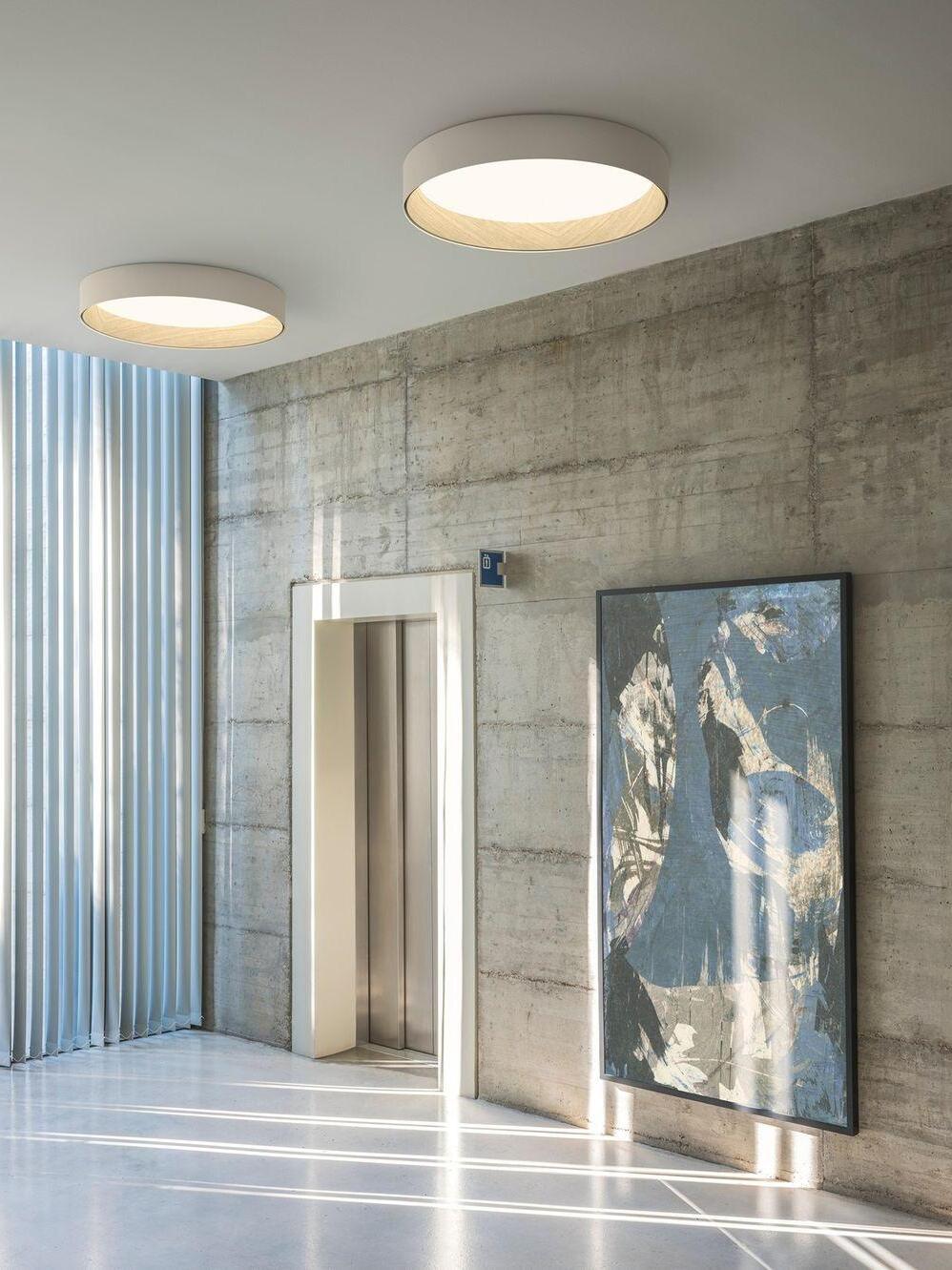 White round ceiling lights by concrete wall