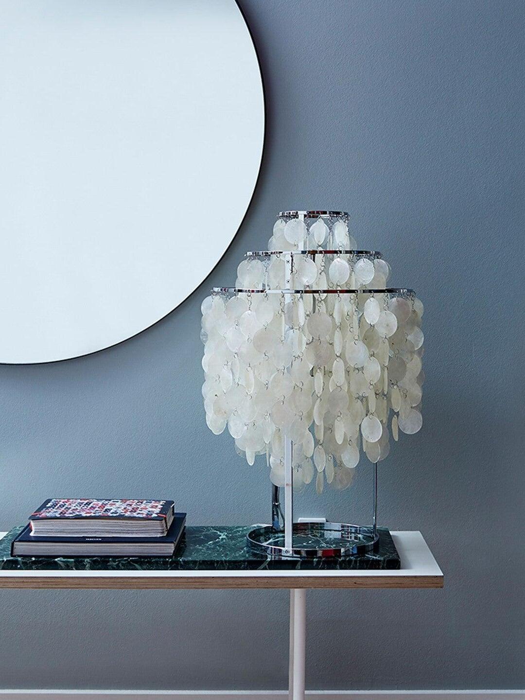 Shell lamp on console below round mirror