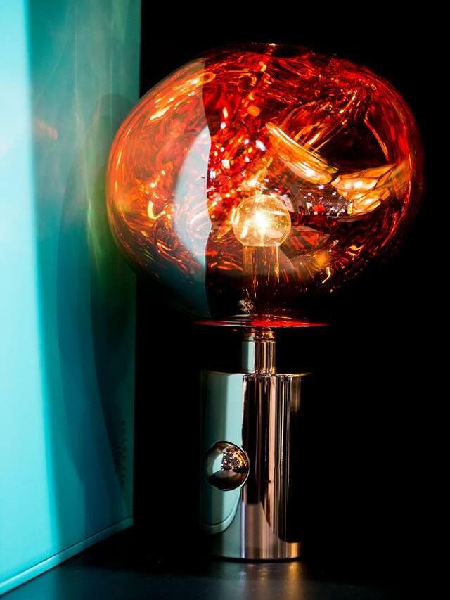 Glowing Melt lamp beside a blue curtain