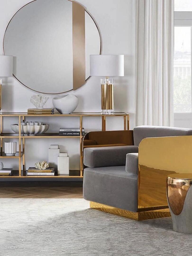 Two white-shade lamps on console beneath round mirror in bright seating room