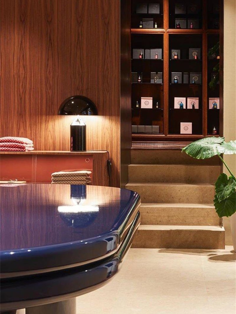 Illuminated black dome table lamp on a wooden counter beside shelves and stairs