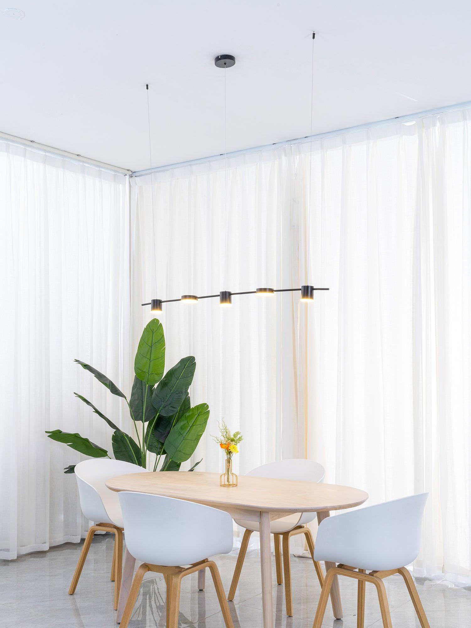 Gold linear fixture above a small dining arrangement