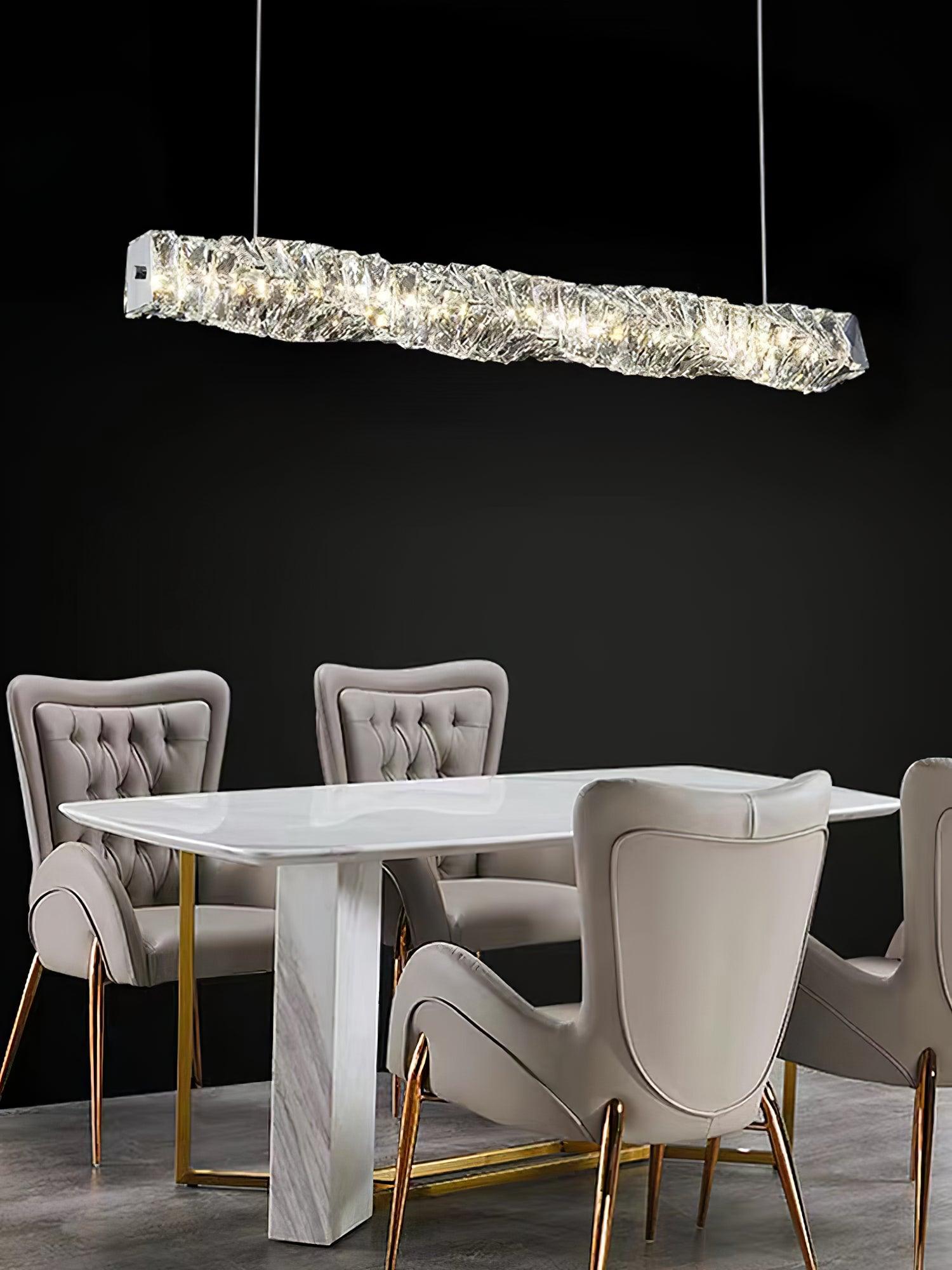 Illuminated crystal pendant above a white dining table and upholstered chairs against a black background