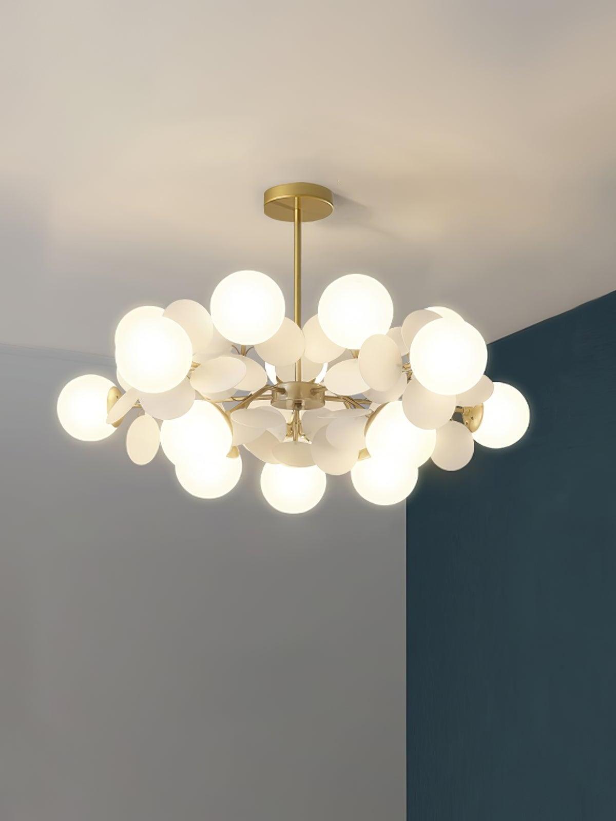 Wide gold chandelier with fifteen white globes and white leaf-like discs