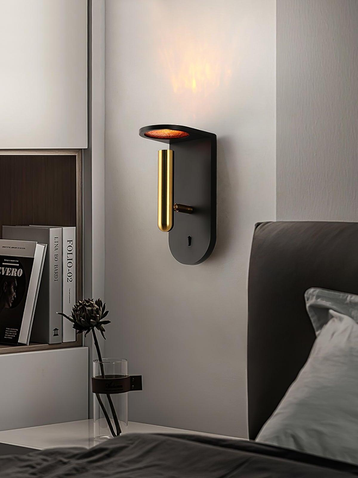 Black Nights wall light beside a grey upholstered bed and a narrow bedside table