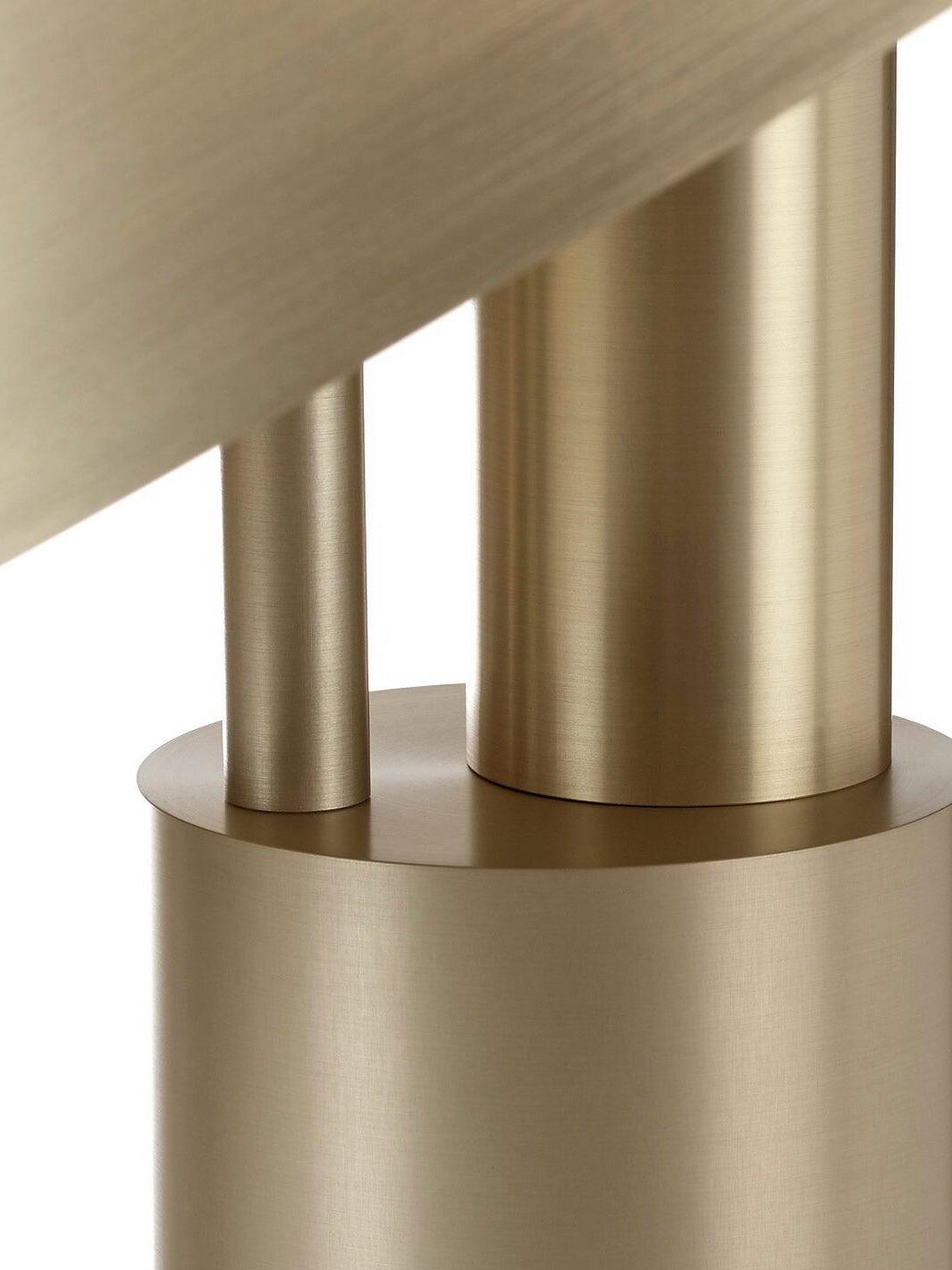 Close view of gold support rods above cylindrical base