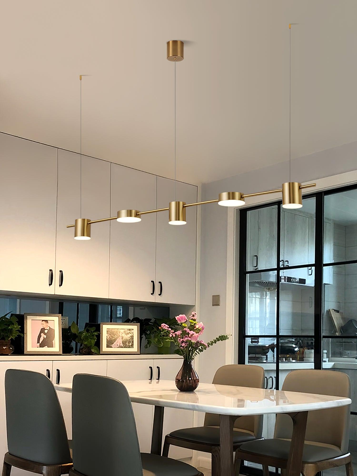 Gold disc-and-cylinder fixture above a round table