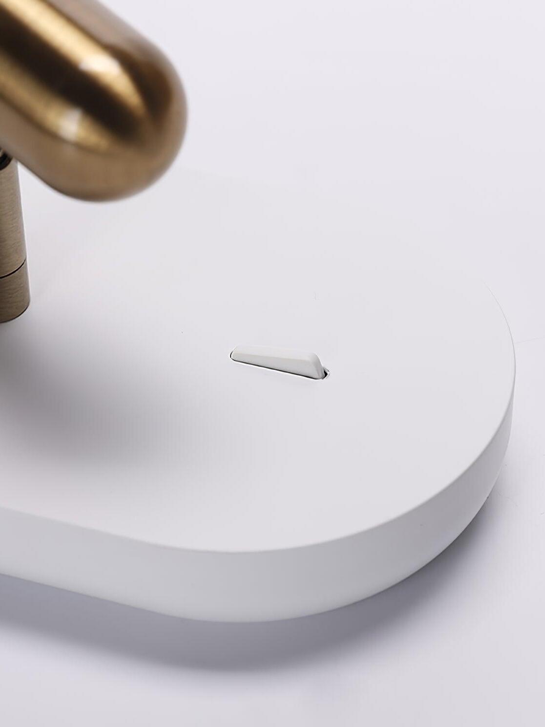 Close-up of the small switch on the white Nights backplate beneath the gold-tone head