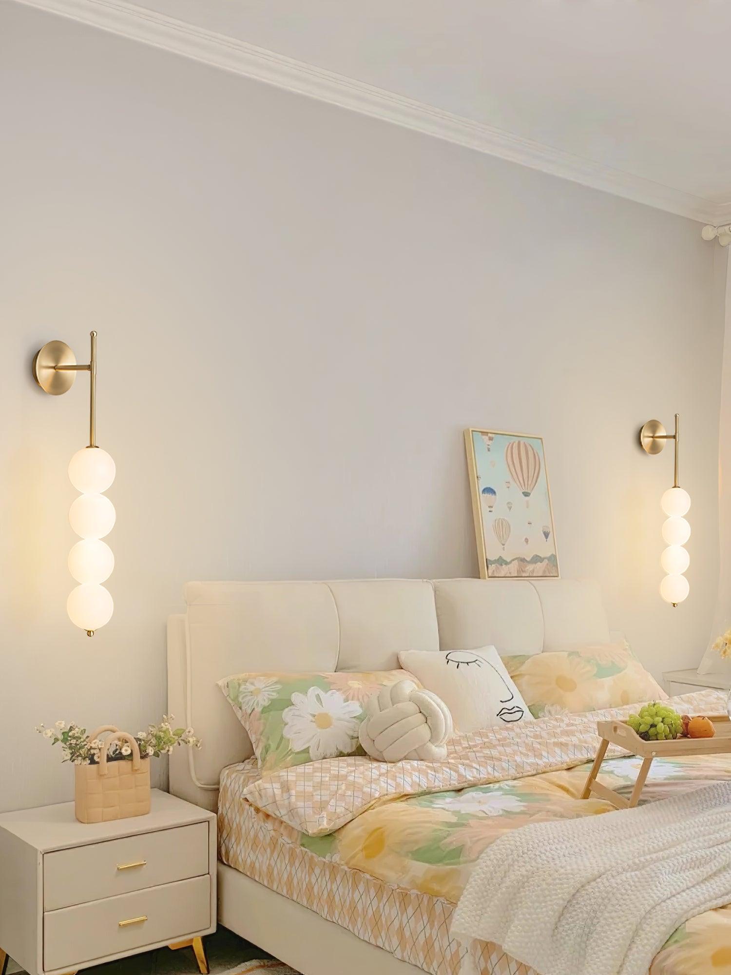Two Brass globe wall lights beside a bed