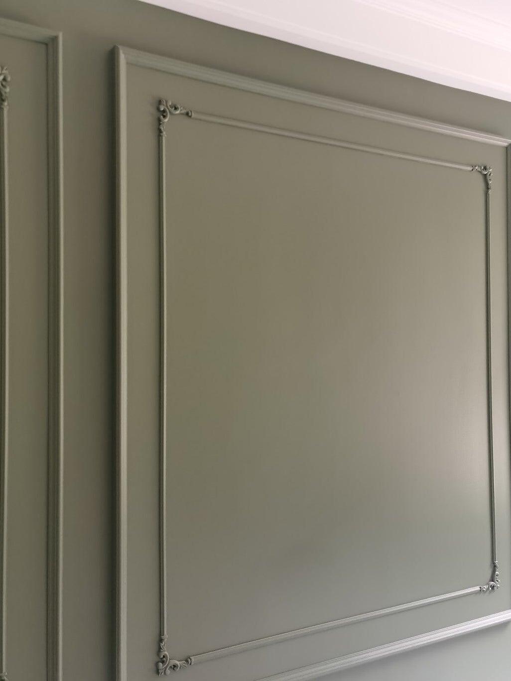 Decorative moulding on a green-grey wall panel