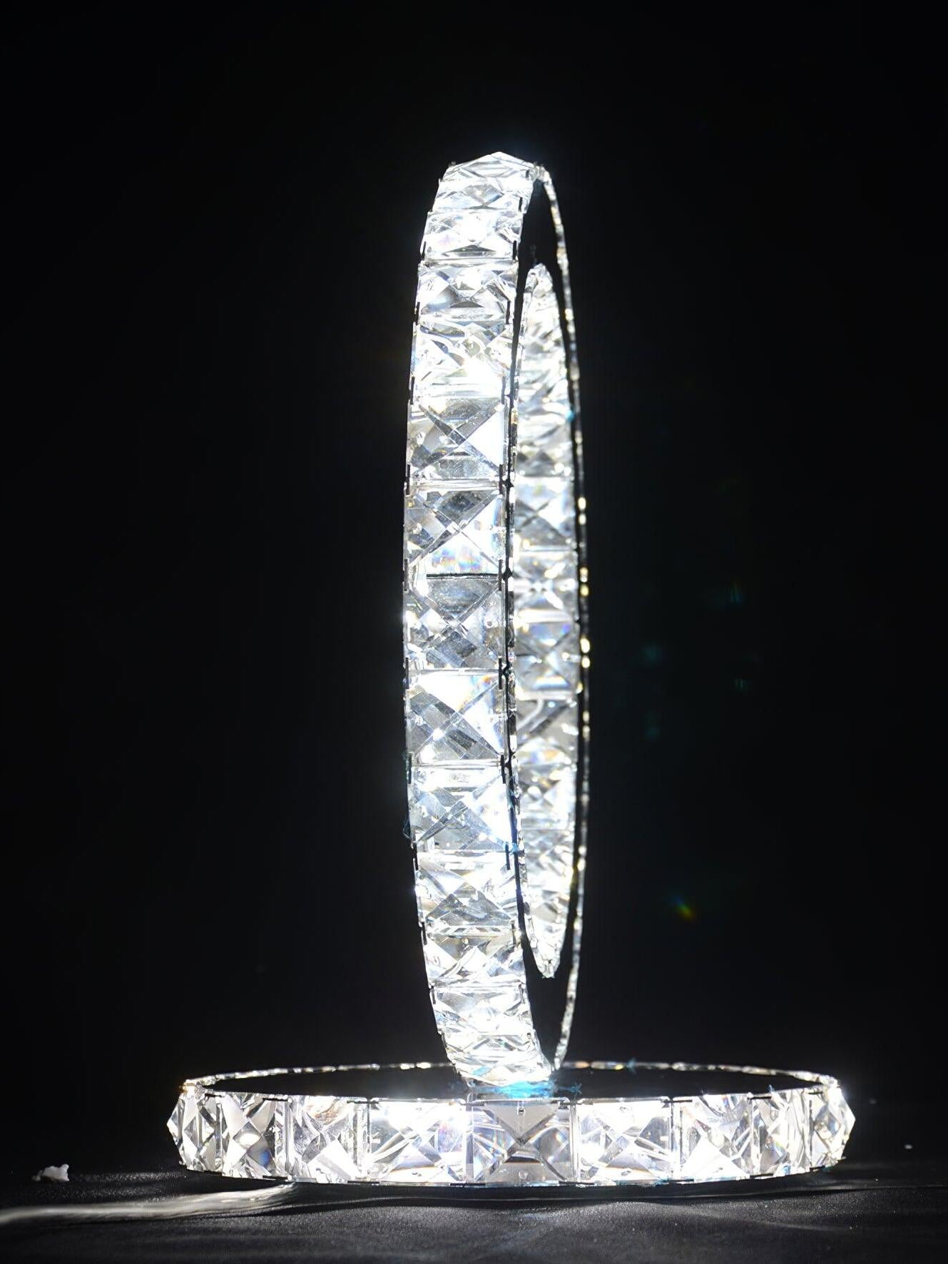 Side profile of the illuminated faceted ring above a round crystal-edged base