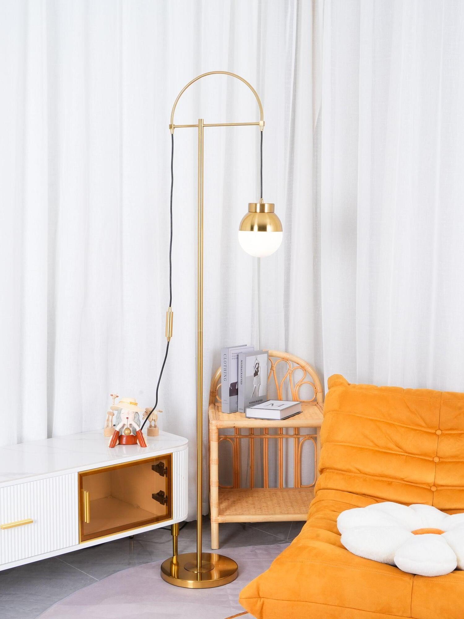 Waterloo Gold arc lamp near an orange chair and wooden toy cart