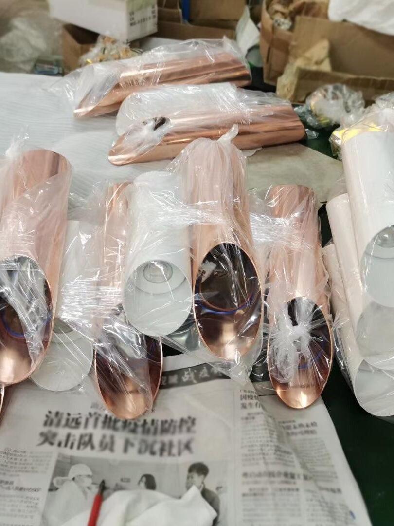 White, rose-gold and black lamp parts in protective wrapping